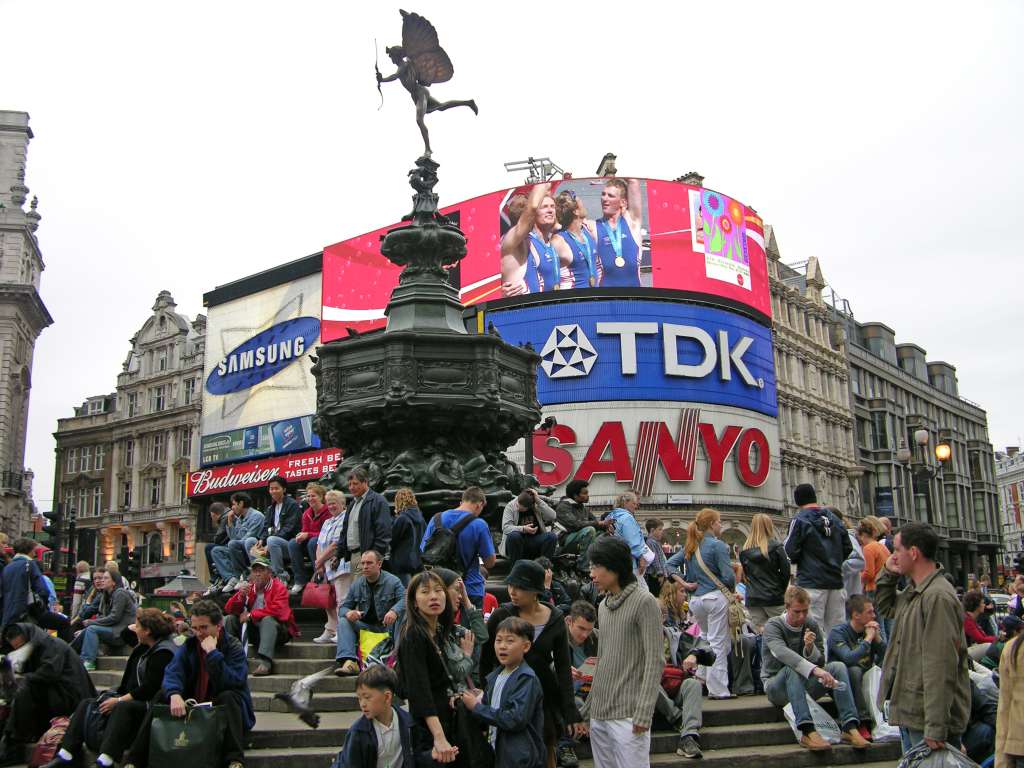 London 01 09 Piccadilly Circus Peter and I walked to the famous London landmark Piccadilly Circus. Backlit by colourful electric displays is a bronze fountain topped by a figure of a winged archer, popularly called Eros, the pagan god of love. The archer was in fact designed in the 19th century as a symbol of Christian charity - a monument to Lord Shaftesbury, a philanthropist. Pete and I played a game of Find Peter. Now, where is he?